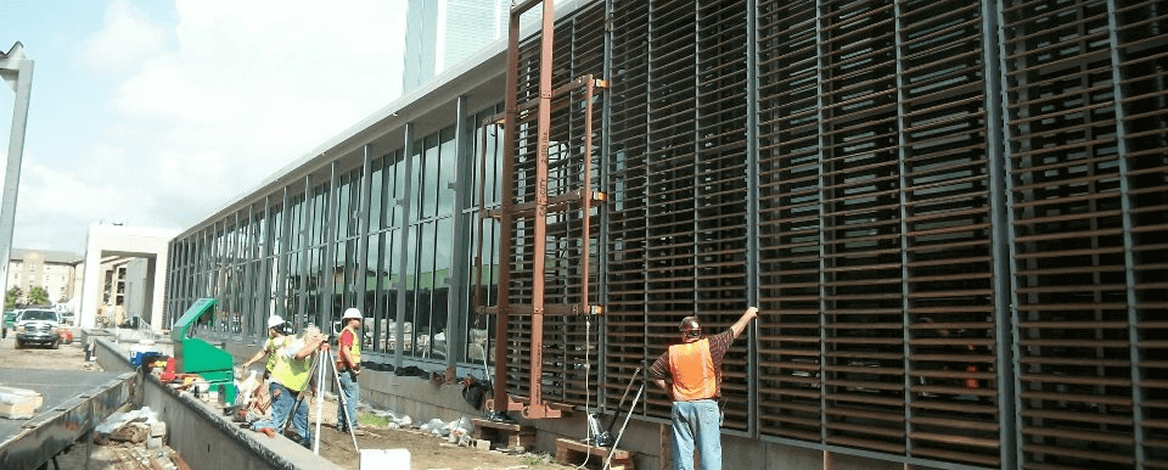 Workers installing facade panels on building